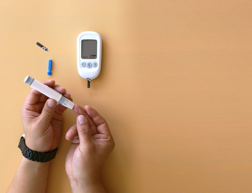 Person using a blood glucose meter to check blood sugar