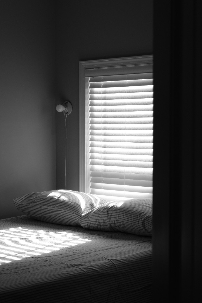 Calm bedroom with morning light through window blinds